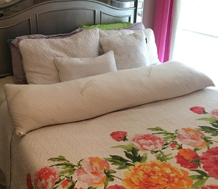 Image showing the white body pillow on floral-patterned sheets.