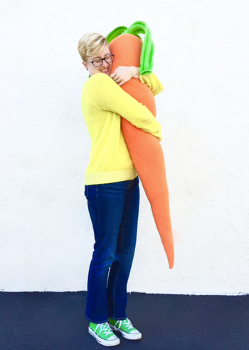 Model embracing the carrot-shaped pillow
