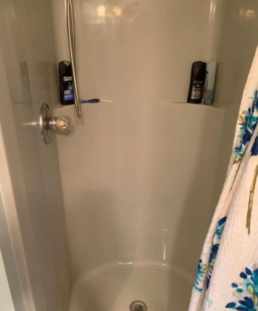 A photo showing the result after cleaning the shower wall, now spotless and rust-free.