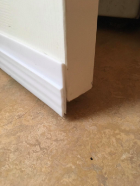 A close-up photo from the reviewer showing the white draft stopper at the base of the door