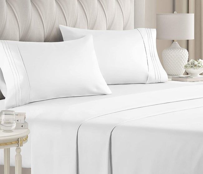 White bed sheets neatly arranged on a bed with matching pillows