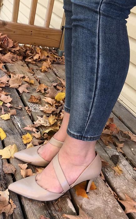 A reviewer showcases the pointed-toe pumps in tan.