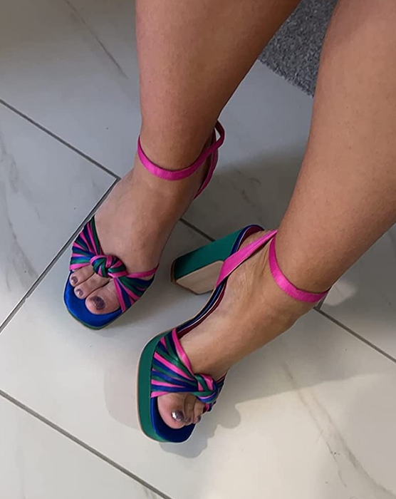 A reviewer is wearing the shoes in a lively mix of pink, purple, green, and blue.