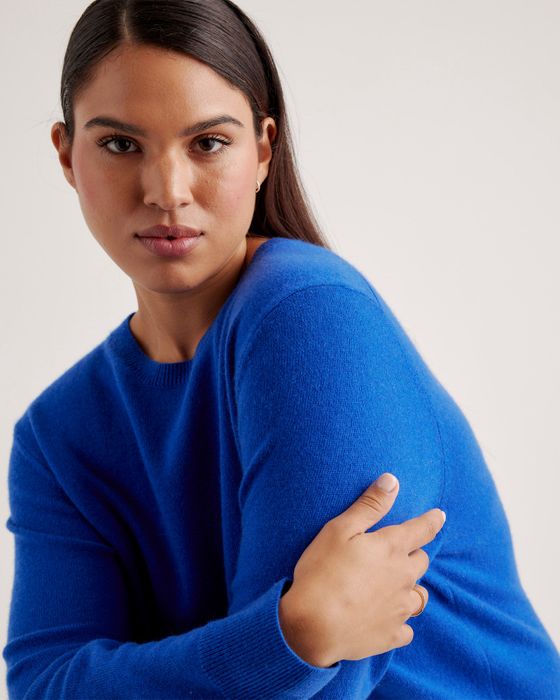 A model is wearing the sweater in bright blue.