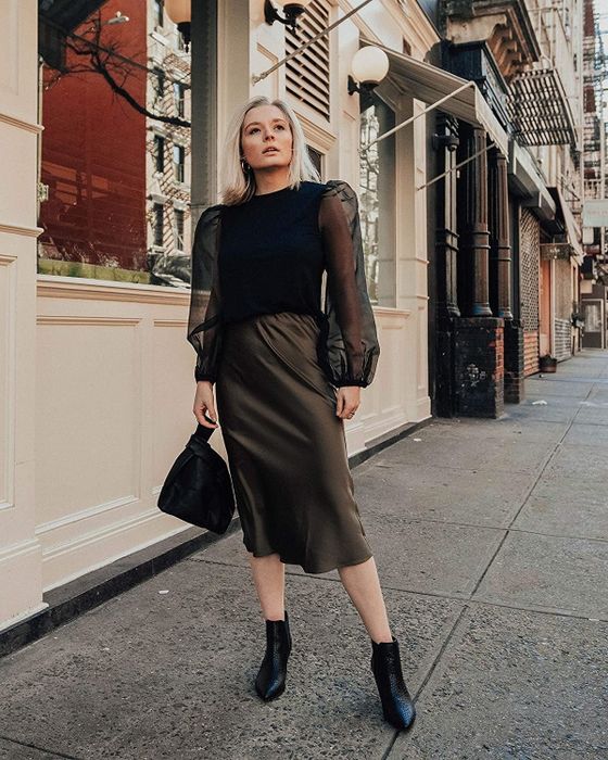 A model is showcasing the skirt in a rich dark olive color.