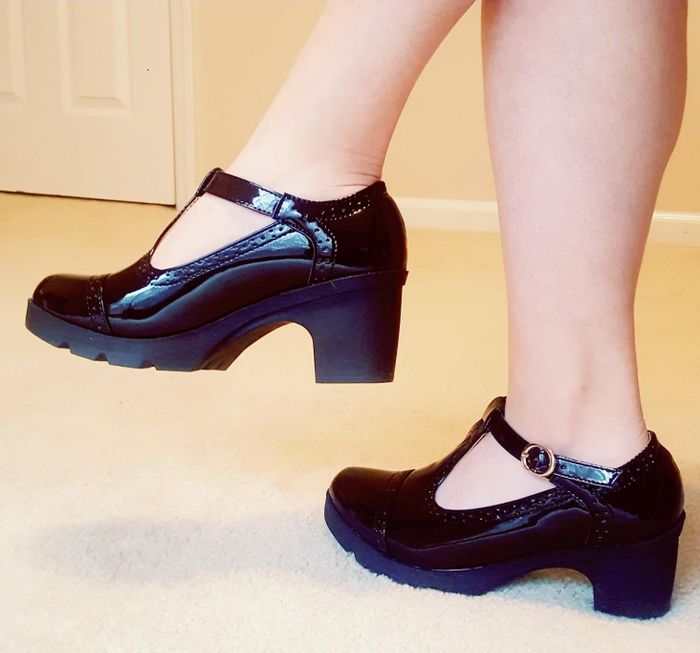 a reviewer sporting platform T-strap sandals in classic black