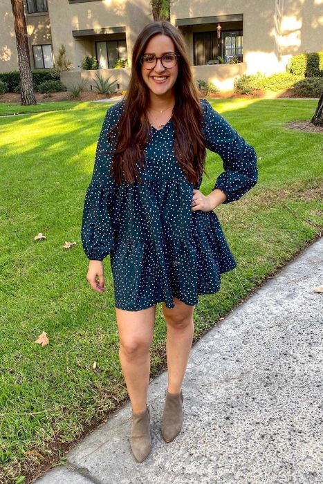 Reviewer wearing the dress in a blue version with white polka dots.