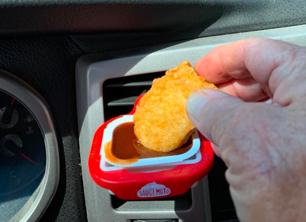 A customer's photo of them using the dip clip, attached to their car vent