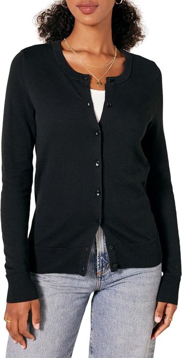 A model styled in a button-down cardigan over a white top and jeans for a shopping guide.