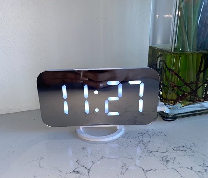 The alarm clock placed on a marble table, showcasing its sleek design.