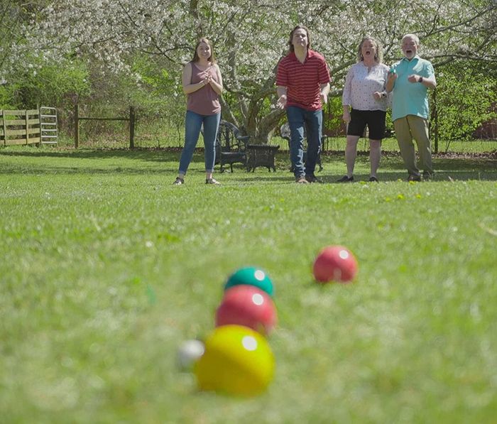 A family enjoys a friendly game of bocce ball together.