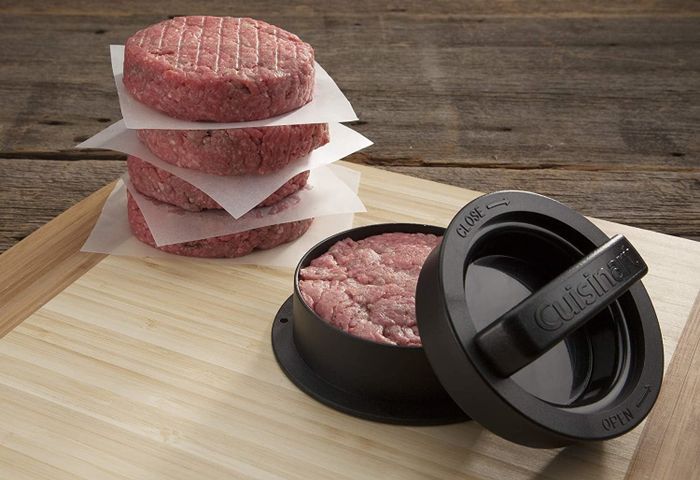 A raw burger patty placed in the press.