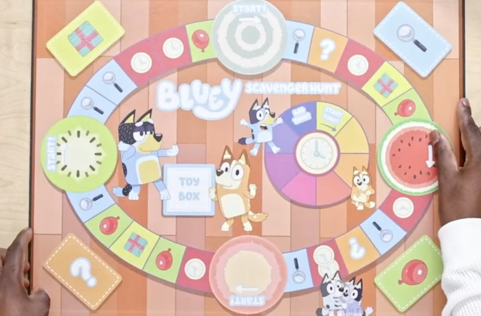 A person is holding a Bluey-themed board game titled.