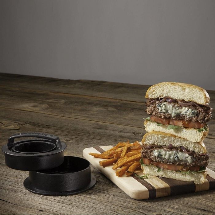 A photo of a delicious cooked burger with melted cheese in the middle.