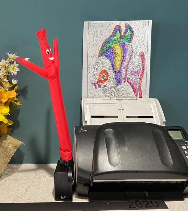 A reviewer's tiny red inflatable tube man sitting on their desk