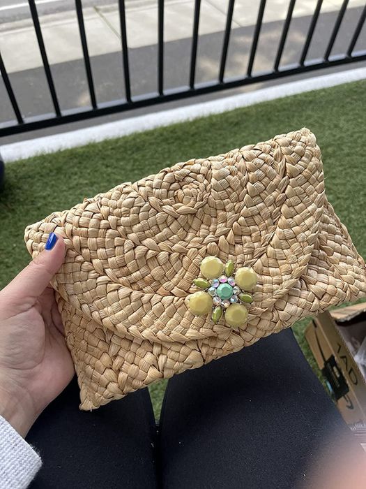A reviewer holding a straw clutch