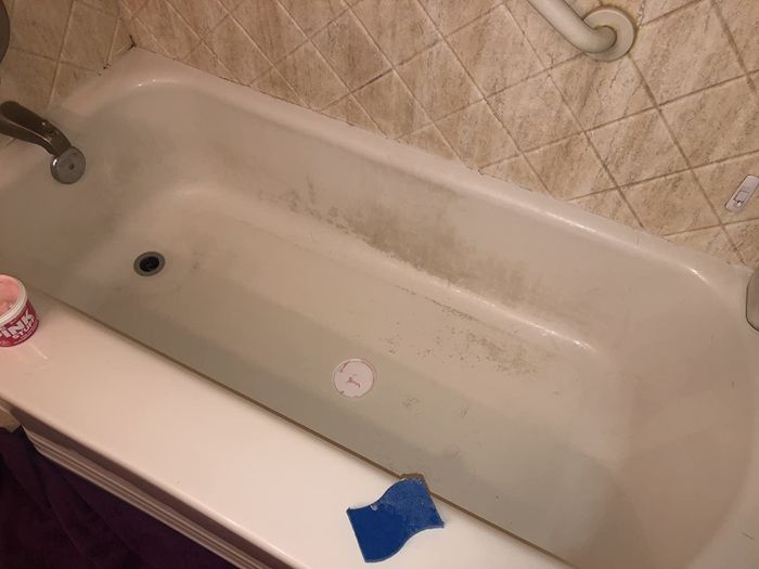 Photo of a reviewer's bathtub covered in grime before using The Pink Stuff