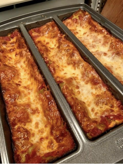 The pan holding three rectangular pieces of perfectly cooked lasagna.