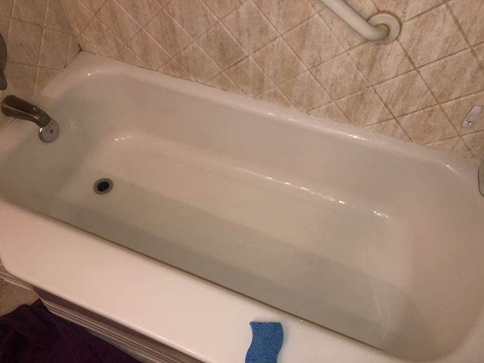 Photo of the same bathtub looking spotless after using The Pink Stuff