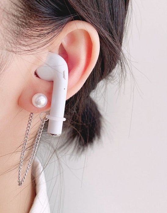 A model sporting the elegant pearl chain earrings that also hold AirPods.