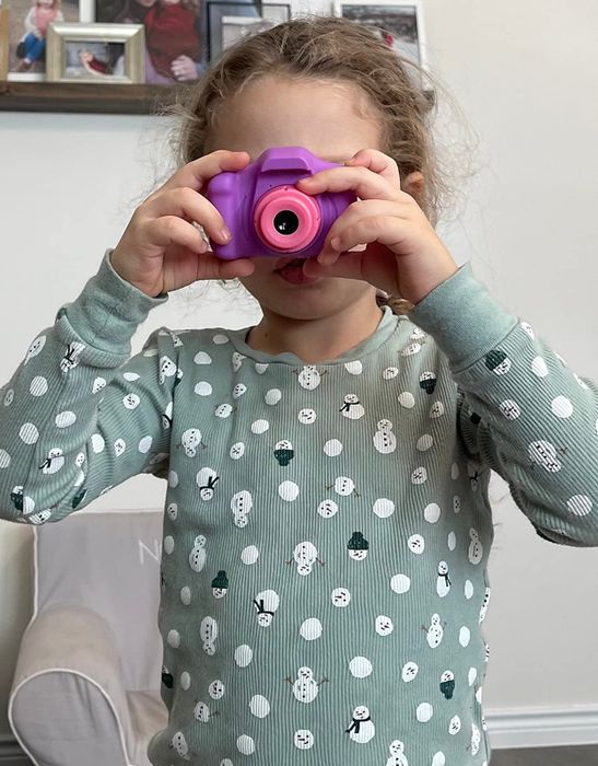 A child holding the camera up to their eyes, ready to capture a photo