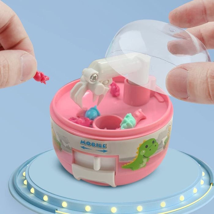Mini claw machine toy with tiny dinosaur figurines