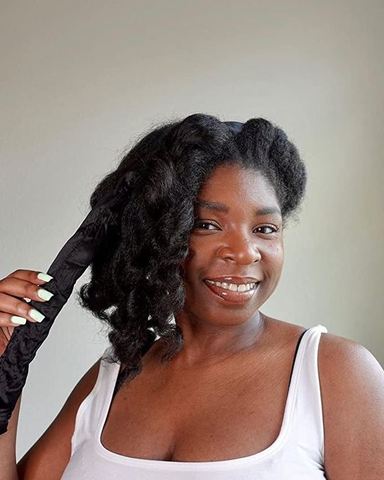 A reviewer showing off their thick curls after removing the rod from their hair.