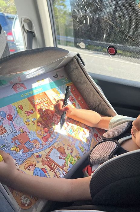 A child playing with the activity mat while in a car.