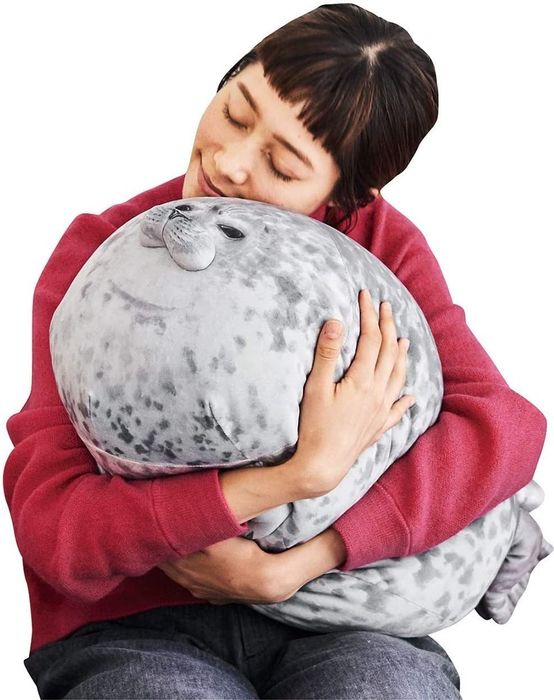A model embracing a soft, seal-shaped pillow