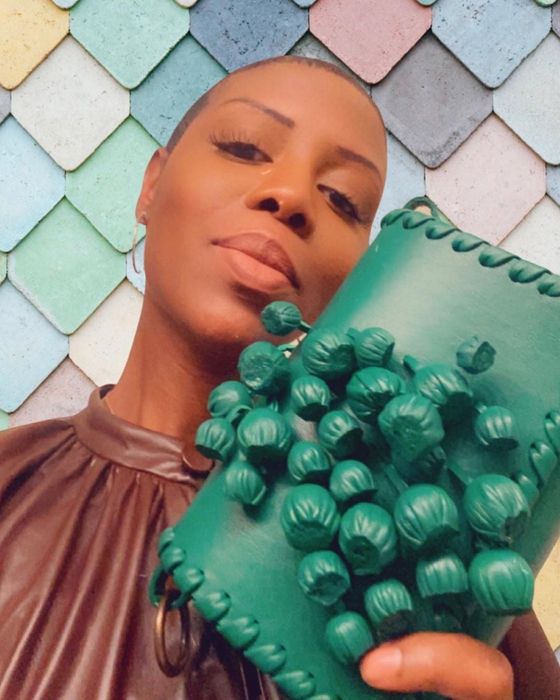 The founder posing with a striking green baubled clutch purse