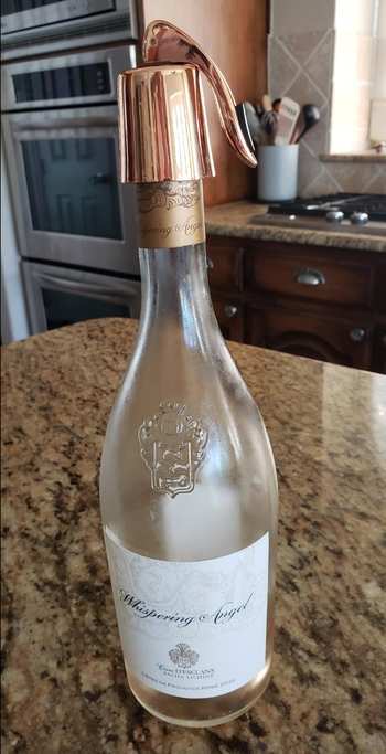 A bottle of rosé with a shiny metallic rose stopper featuring a convenient lever.