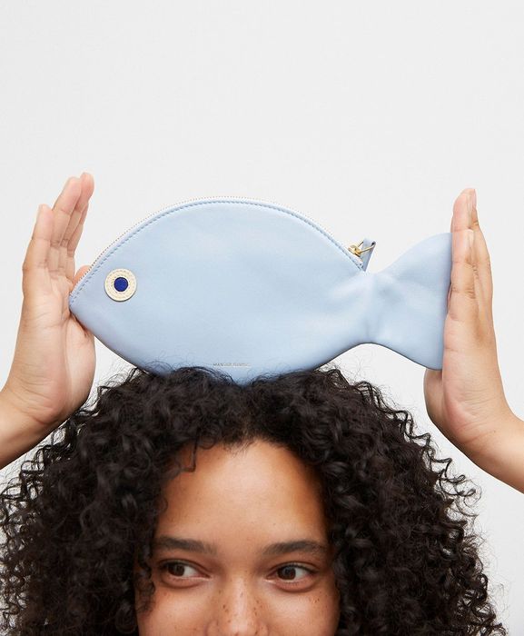 A model with a fish-shaped clutch perched on her head.
