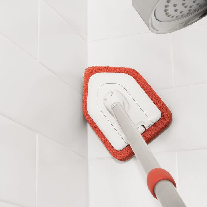 The OXO extendable scrubber in action on shower tiles