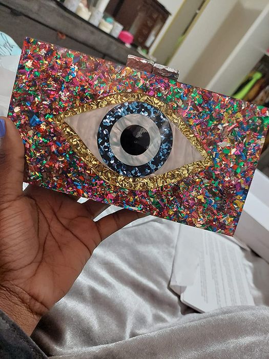 A reviewer presenting a sparkling clutch purse