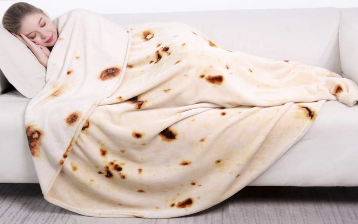 A model tucked in a blanket that resembles a tortilla wrap.
