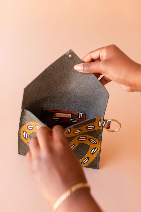 An individual opening the envelope clutch.