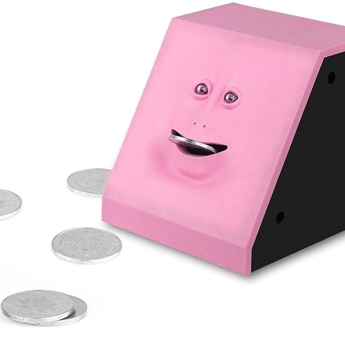 The pink piggybank with its mouth wide open and a coin inserted