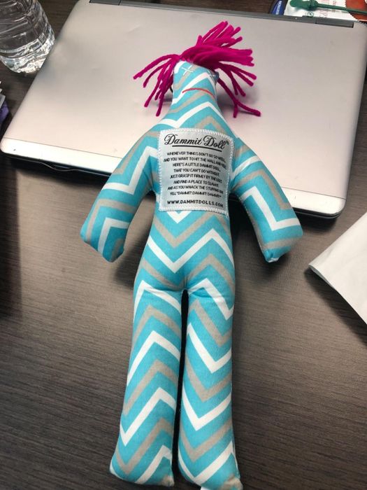 A reviewer's blue, white, and grey chevron-patterned Dammit doll.