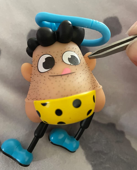 a reviewer using tweezers to carefully extract a strand of hair from a keychain