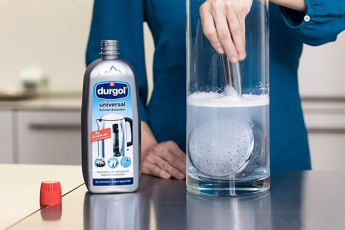 A model soaks the showerhead in Durgol universal descaler, effectively cleaning away buildup.