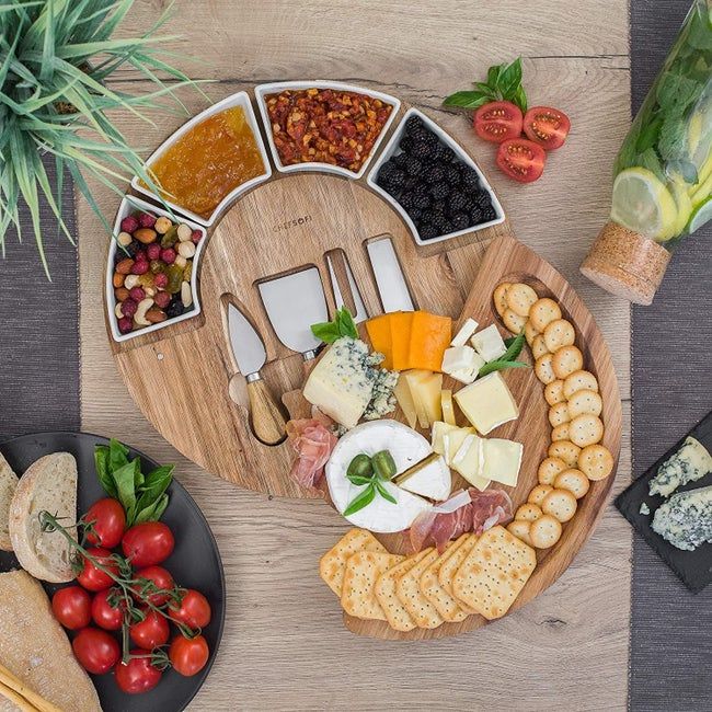 A round charcuterie board with two layers that open up to reveal extra space for serving.