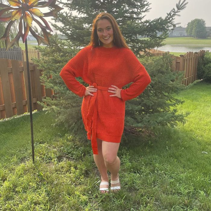 A model showcasing the dress in vibrant orange.