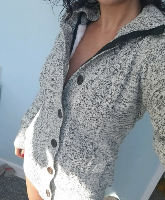 A customer photo capturing them in the sweater, styled in a chic gray tone.