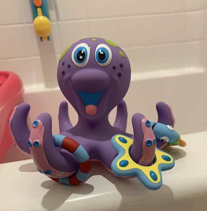 A reviewer’s picture of a purple plastic octopus with colorful rings on its tentacles, adding a playful touch to bath time.