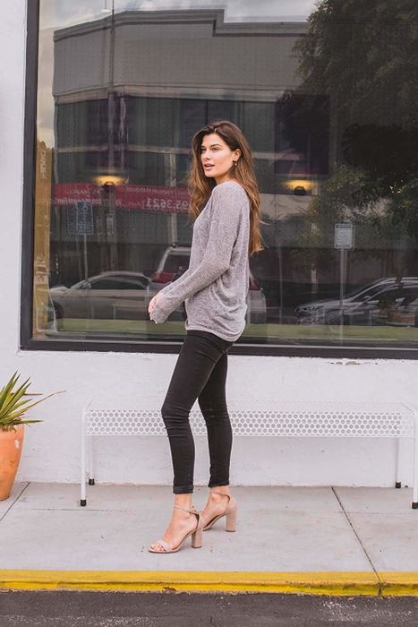 A model confidently struts in the sweater, showcasing its style.