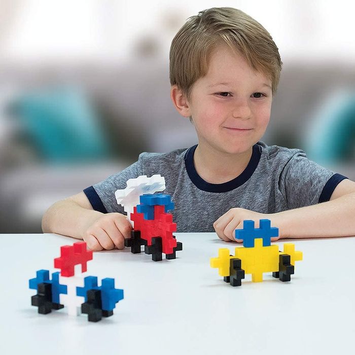 A child playing with vibrant and colorful PlusPlus building toys, bringing their creations to life.