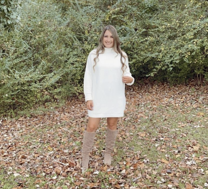 A customer review image showing them wearing the dress surrounded by a lush field of greenery.