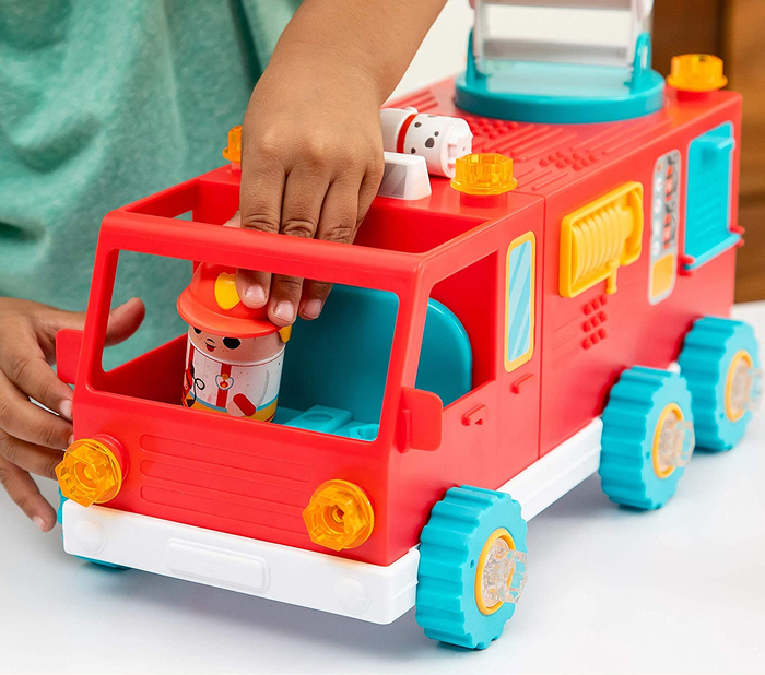 A child playing with a red plastic fire truck toy