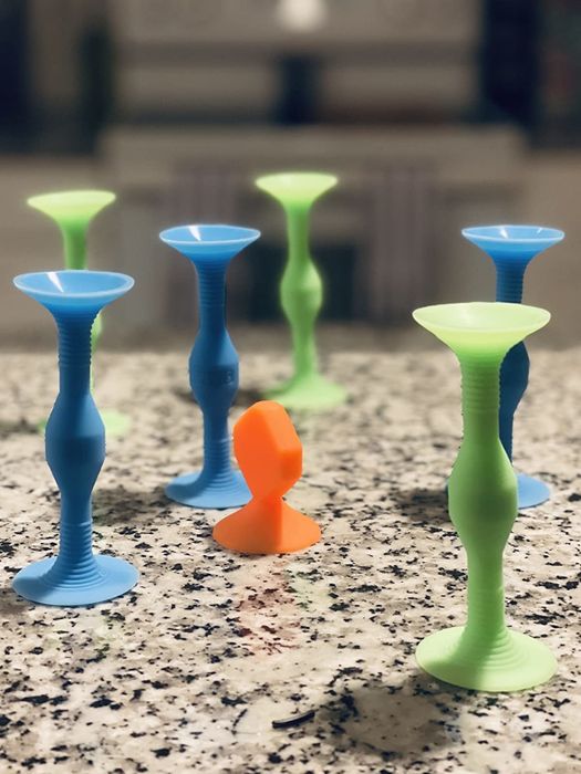 A reviewer's photo showing green, blue, and orange Popdarts stuck to a countertop