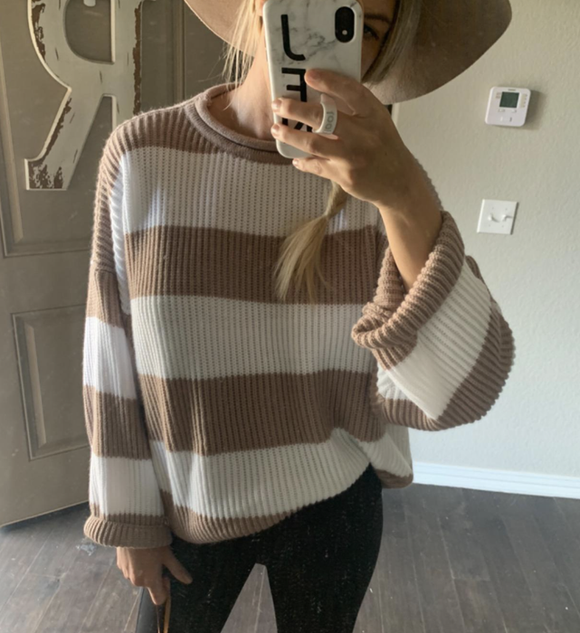 A customer-uploaded photo of them taking a mirror selfie while wearing the sweater